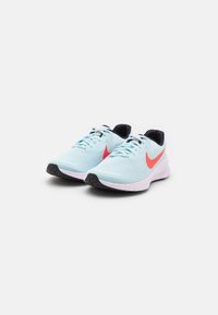 Baskets de sport bleu clair avec une tige en maille, un swoosh Nike rouge, des accents noirs et une semelle intermédiaire speckled blanche et rose. Semelle extérieure en caoutchouc.