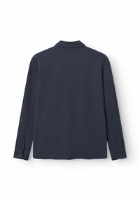 Camisa de manga larga azul marino con una tela texturizada, puños abotonados y un cuello. La parte trasera presenta un diseño limpio y sencillo.