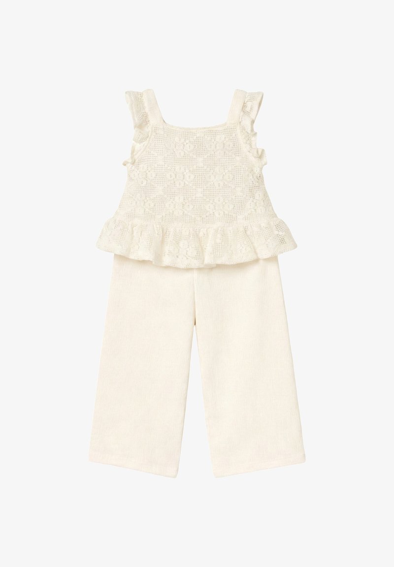 Top sin mangas de color crema con patrón de encaje floral y dobladillo con volantes combinado con pantalones anchos texturizados en crema.