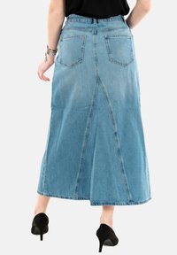 Lichtblauwe denim maxi rok met een voorknip, vijf zakken en een hoge taille. Bevat stikseldetails en een gladde textuur.