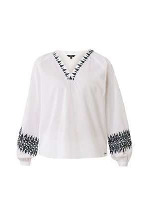 Blusa blanca de manga larga con escote en V, que presenta patrones de hojas bordados en negro a lo largo del escote y los puños. Hecha de una tela ligera.
