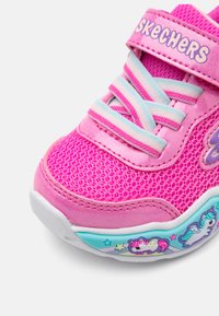 Skechers tenisky v žiarivej ružovej sieťovine, s tyrkysovými akcentmi, pruhovanými šnúrkami a dekoračným dizajnom jednorožca na podrážke.