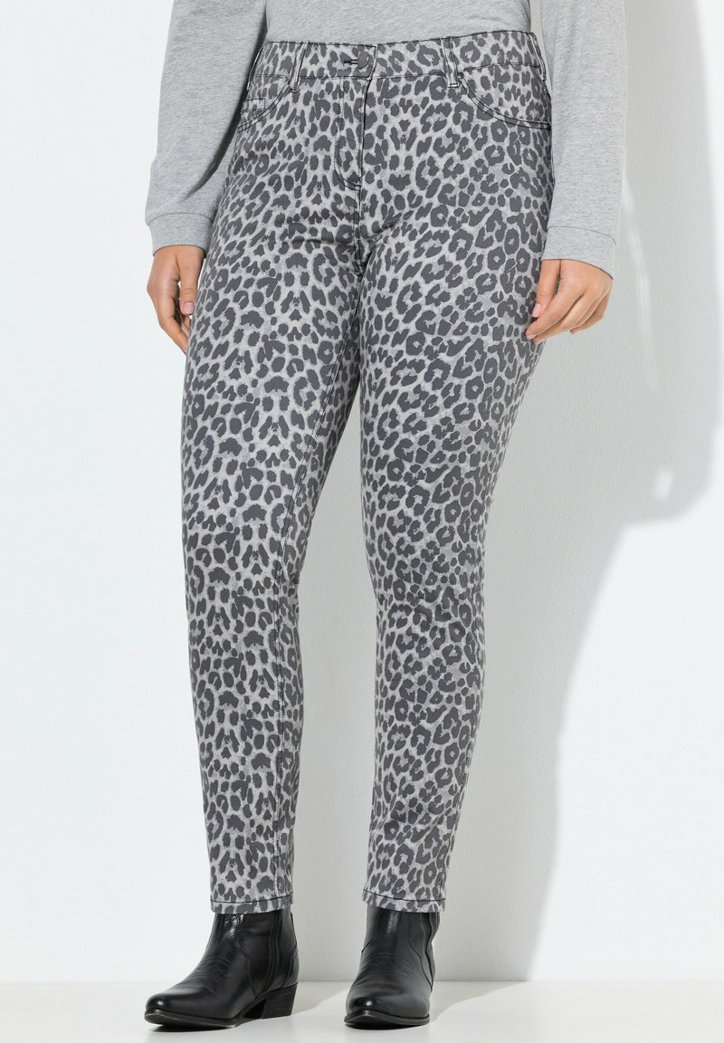 Jeans a stampa leopardata grigia con vestibilità slim, cinque tasche e vita media, abbinati a stivali alla caviglia neri. Tessuto morbido e strutturato.