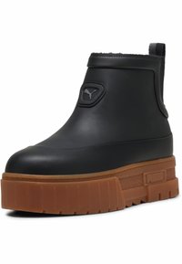Zwarte platformen enkelboots van soepel synthetisch materiaal met een rubberen zool. Bevat een logopatch en een getextureerde tussenzool.