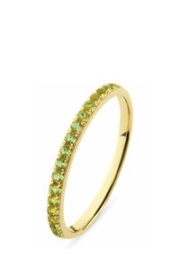 Guldbelagt ring med en smal band prydd med jämnt fördelade gröna ädelstenar, som visar en slät yta och ett starkt färgkontrast.