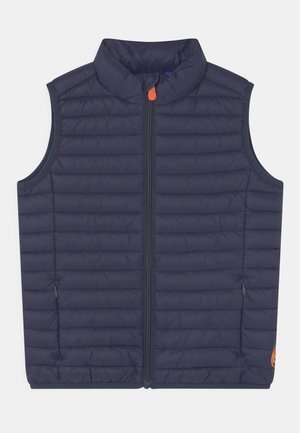 Marineblaue isolierte Weste mit hohem Kragen, Frontreißverschluss, gesteppter Textur und Seitentaschen. Verfügt über einen orangen Reißverschlussanhänger und Logodetail.