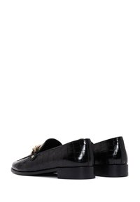 Schwarze Loafers mit glänzender Oberfläche, die eine Krokodilprägung, goldfarbene Hardware-Akzente und einen niedrigen Blockabsatz aufweisen.