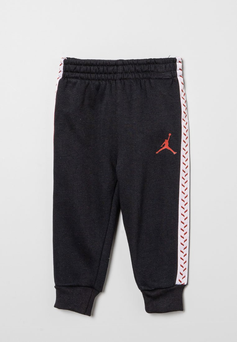 Pantaloni da tuta neri con vita elasticizzata, strisce laterali bianche con motivo a zigzag rosso e logo Jordan rosso sulla coscia sinistra.