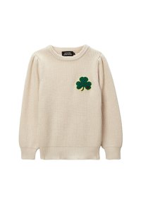 Pull en tricot couleur crème avec un col rond. Présente un patch en feutre vert en forme de trèfle sur la poitrine gauche. Manches et ourlet à côtes.