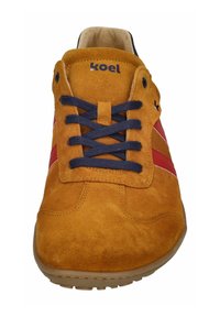 Herren-Sneaker mit einem Obermaterial aus Wildleder in Senfgelb, mit marineblauen Schnürsenkeln, roten und dunkelroten Streifen sowie einer Gummisohle.