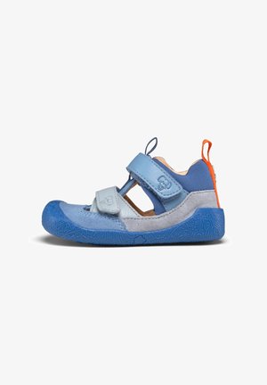 Blue children's sandal with a mix of smooth and textured materials, Velcro straps, and a patterned rubber sole. Accent orange heel tab.