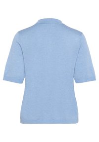 Lichtblauwe polo met korte mouwen, geribbelde kraag en een zachte textuur. Heeft een rechte snit en geen zichtbare patronen of accenten.
