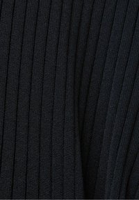 Gros plan sur un tissu en maille côtelée noire montrant des lignes texturées verticales et un détail de couture fine.