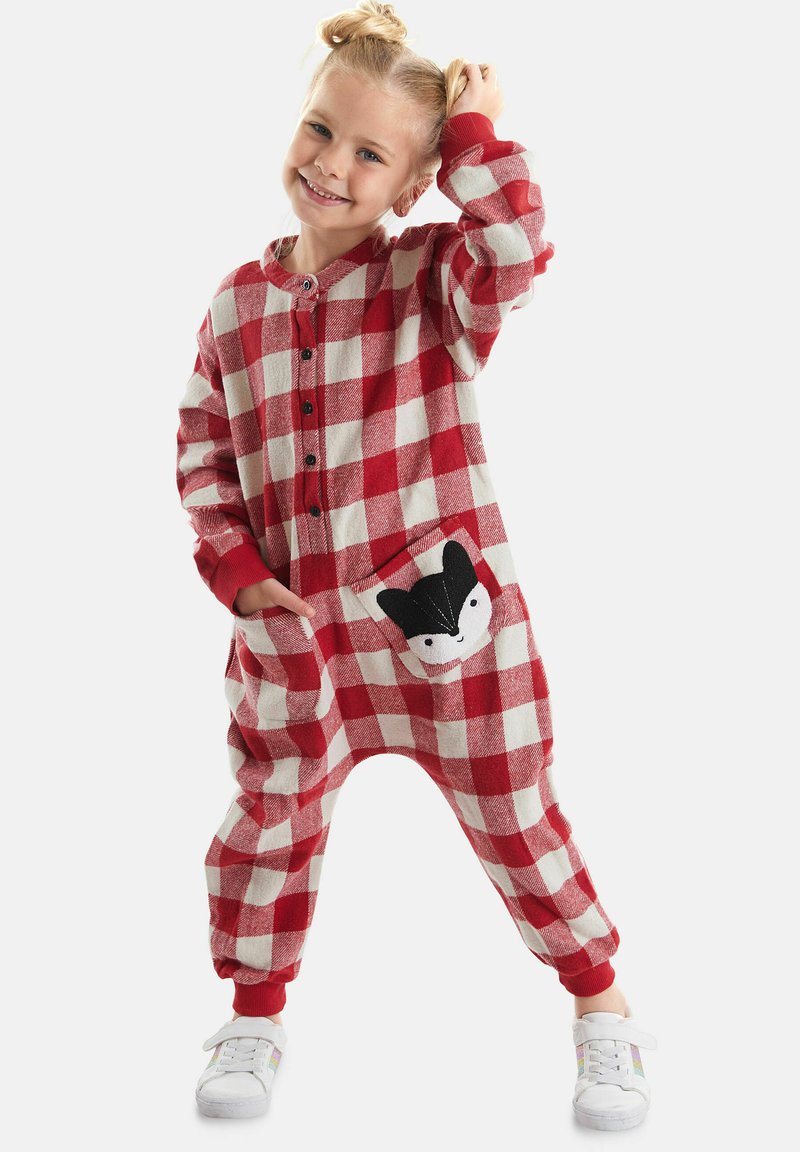 Un pelele de cuadros rojos y blancos hecho de tela suave que presenta un frente con botones y un bolsillo con un diseño de zorro en blanco y negro. Los puños elásticos completan el look.