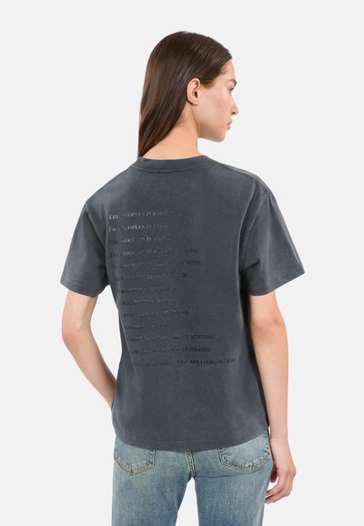 T-shirt en coton gris avec un texte en relief de tailles variées au dos, à manches courtes et à coupe décontractée.