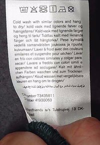 Pesusilt näitab külma pesu 40°C juures, mitte valgendit, mitte trummelkuivatust, rippkuivatust, madalat triikimist, mitte keemilist puhastust mitmekeelsed pesujuhised.