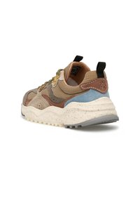 Sneaker multicolore con tomaia testurizzata e accenti marroni, verdi e blu, suola intermedia maculata di bianco e linguetta nera sul tallone.