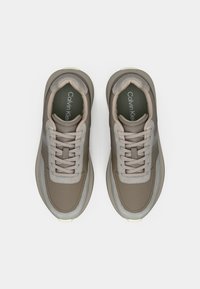 Αθλητικά παπούτσια Calvin Klein με μπεζ και γκρύ χρώμα, υλικά από υφή δέρματος και πλέγμα, επίπεδες κορδόνες και μαλακό περιλαίμιο.