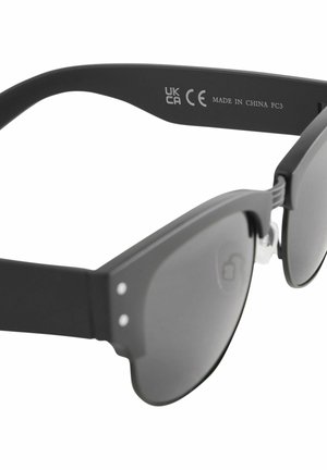 Čierne slnečné okuliare s matným povrchom, s jedinečným vyrezávaným dizajnom, tmavými sklami a malými striebornými akcentmi na rámoch.