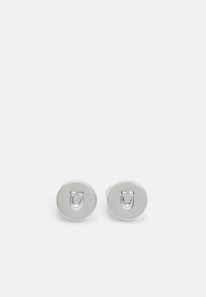 Par de pendientes de botón redondos de plata, cada uno con un diseño en relieve de herradura en el centro sobre un fondo blanco liso.