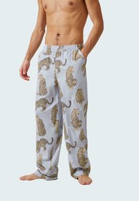 Lichtblauwe pyjamabroek met een overal panterprint in bruin en zwart. Elastische tailleband met zijzakken, gemaakt van ademende stof.