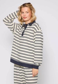 Pasiasty sweter w kolorze kremowym i granatowym, z kołnierzykiem, z przodu zapinany na guziki oraz długimi rękawami z prążkowanymi mankietami. Miękka, strukturalna tkanina.