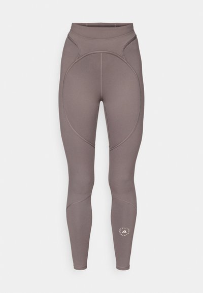High-waisted taupe leggings with curved seam details and a small round logo near the lower right leg.