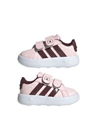 Scarpe da ginnastica rosa e bianche con pois, dettagli marroni, dotate di due cinturini in Velcro e suola bianca. Materiale liscio e design a punta rotonda.