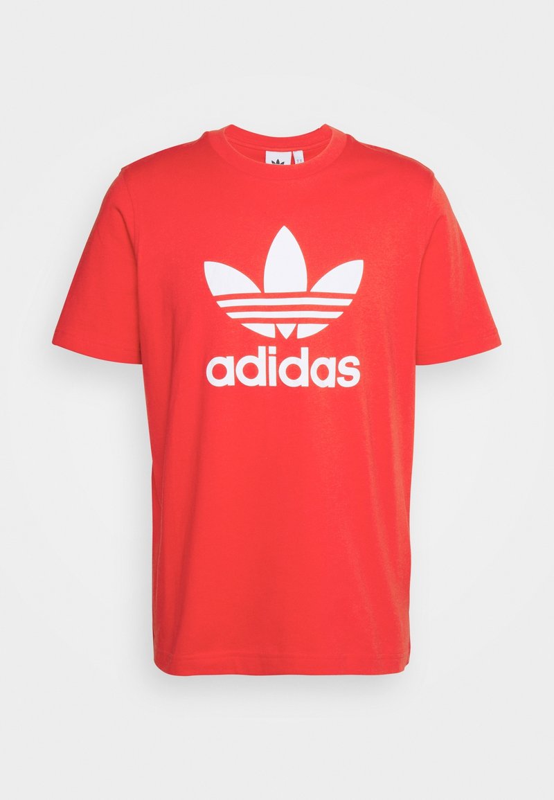 T-shirt rossa in cotone con collo rotondo e maniche corte. Presenta un grande logo Adidas trefoil bianco e tre strisce orizzontali sotto di esso.