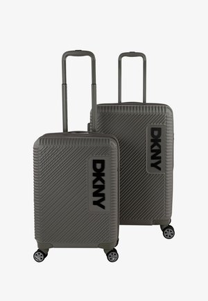Dos maletas rígidas de DKNY en gris con un diseño texturizado de costillas diagonales, con acentos de logotipo en negro y cuatro ruedas multidireccionales.