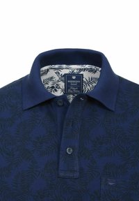 Marineblå polo t-shirt med et subtilt bladmønster, kort krave, tre knapper og en kontrasterende hvid inderside med et løvmønster.