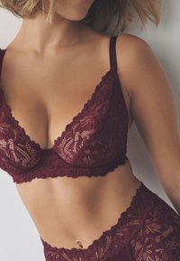 Bordová čipkovaná braletka so štvorcovým tvarom, nastaviteľnými ramienkami a vlnitými okrajmi, doplnená o zodpovedajúce čipkované vysoké nohavičky.