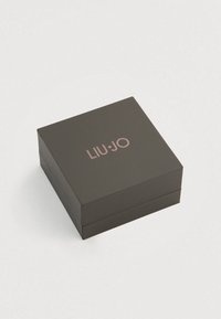 Négyzet alakú fekete ajándékdoboz matt felülettel, rajta a fedélen rózsaarany "LIU·JO" logó dombornyomott kivitelben. Elegáns és letisztult design.