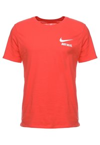 Červené tričko s krátkým rukávem značky Nike s bílým nápisem "Just Do It." a logem swoosh na levé části hrudi.