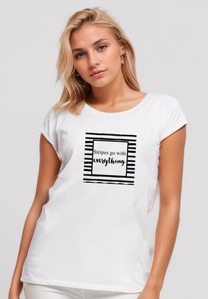 White short-sleeve T-shirt featuring a black and white striped graphic with the text "Stripes go with everything" in a bold font.