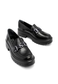 Czarne skórzane lordsy z grubą podeszwą platformową, z dekoracyjnym łańcuchem na przodzie. Gładka tekstura i fason wsuwany.