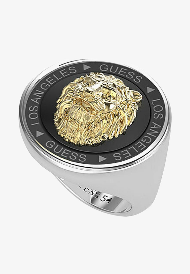 Anello d'argento con un faccia circolare nera e una testa di leone dorata in rilievo, circondata dalle iscrizioni "LOS ANGELES" e "GUESS".