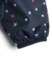 Navy modrá nepromokavá látka se staženým manžetou, zdobená vícemočnými tečkami a hvězdami v odstínech růžové, světle modré a lilákové.