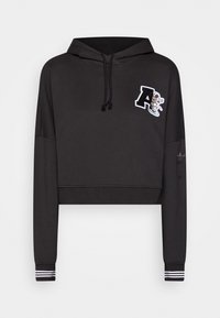 Black cropped hoodie with a drawstring hood, featuring a white embroidered letter "A" and a graphic accent. Ribbed cuffs with black and white stripes.