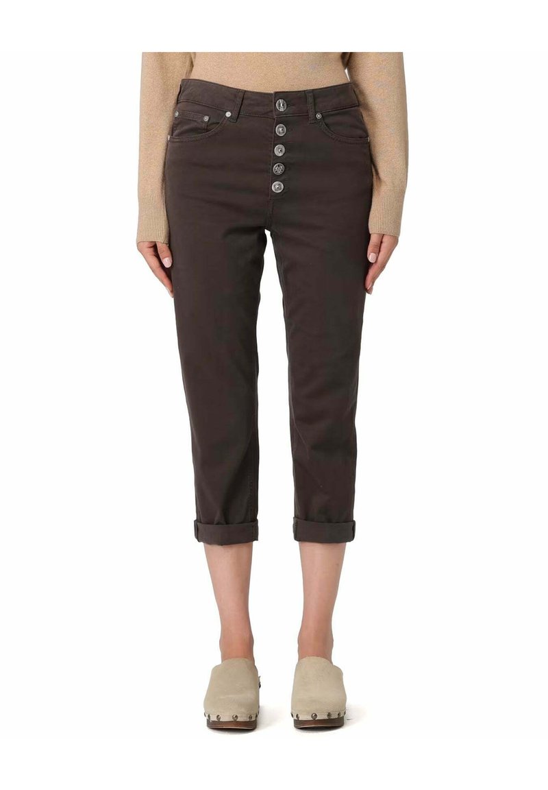 Pantalon court marron foncé avec fermeture à boutons sur le devant, cinq poches, revers roulés et texture en coton lisse. Accompagné de sabots beiges.