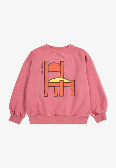 Roze sweatshirt met lange mouwen, geribbelde manchetten en onderrand. Heeft een grafische print van een stoel met een gele zitting en oranje details.