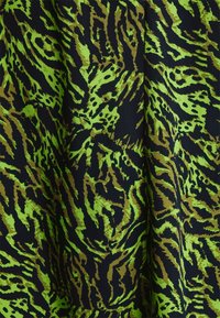 Textile with a black background featuring a bold green and brown zebra pattern. The fabric has a smooth, shiny texture.