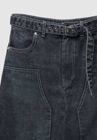 Pantaloni di denim nero con una fascia ampia in vita, dotati di cintura, accessori in argento, tasche frontali e cuciture a contrasto per un dettaglio aggiuntivo.