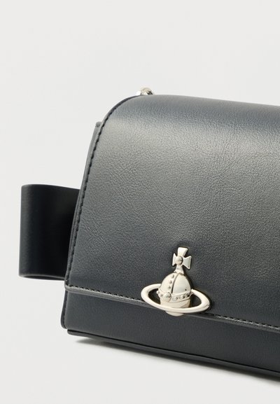 Μαύρο δερμάτινο τσάντα με στρογγυλεμένο σχήμα, αξεσουάρ σε ασημί τόνο και διακοσμητικό με θέμα τον πλανήτη στο μπροστινό καπάκι. Ομαλή υφή.