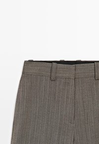 Grijze broek met een herringbone-patroon en een vlakke voorkant, met een rechte tailleband en riemlussen. Gemaakt van textuurstof.