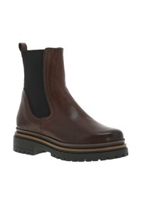 Bottine en cuir marron avec panneaux latéraux élastiques, talon empilé et semelle en caoutchouc avec des rainures pour une meilleure traction. Texture lisse avec un léger éclat.