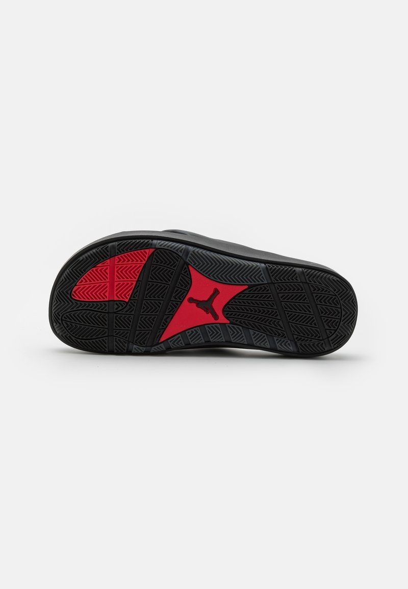 Czarna sportowa podeszwa buta z teksturowanym wzorem antypoślizgowym. Zawiera czerwone akcenty w kształcie gwiazdy oraz logo marki wkomponowane w design.