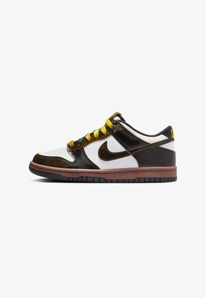 Las zapatillas Nike de corte bajo presentan una parte superior blanca con acentos en negro y marrón, cordones amarillos y verdes, y una suela de goma con una entresuela marrón.