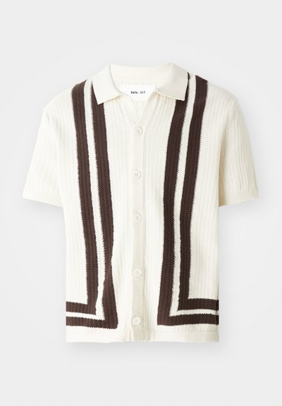Kardigan z krótkim rękawem w kolorze kremowym z ciemnobrązowymi paskami. Posiada teksturowany splot, standardowy kołnierzyk oraz pięć guzików z przodu.