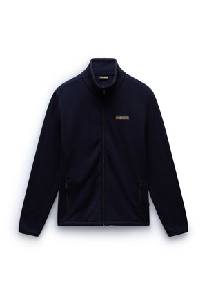 Merinäky fleece-takki, jossa on korkea kaulus, täysipitkä vetoketju edessä, kaksi sivutaskua ja pieni logo-yksityiskohta rinnassa. Pehmeä pinta ja istuva muotoilu.